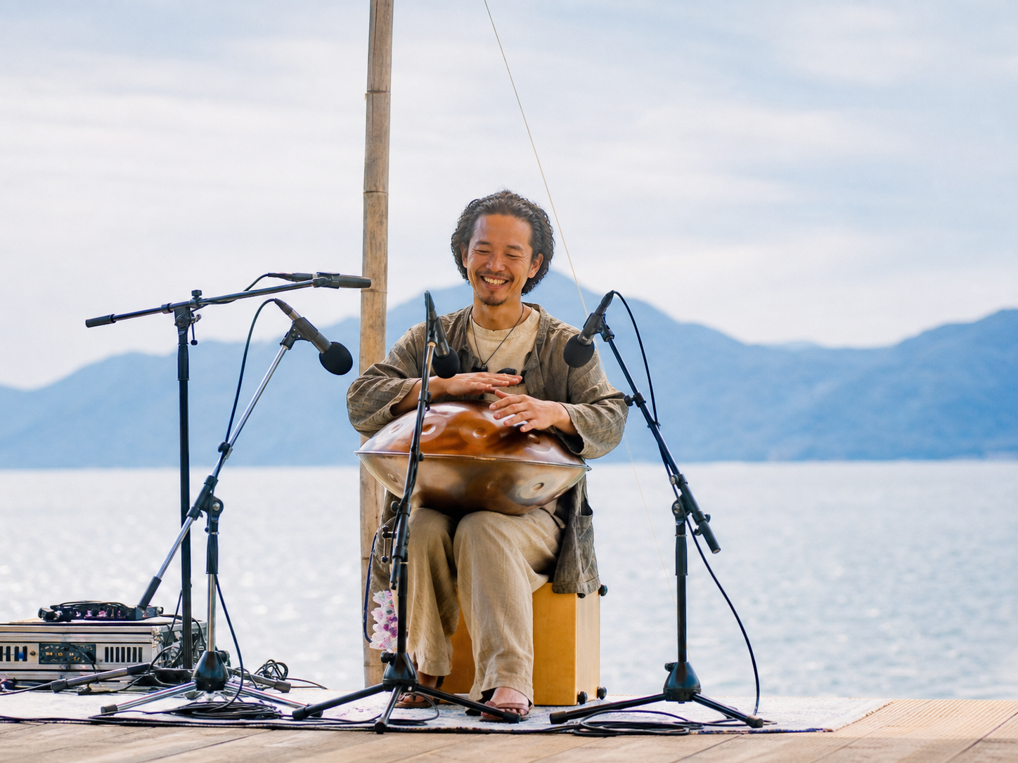 水辺でハンドパンを演奏するmasahiro kumamotoさん